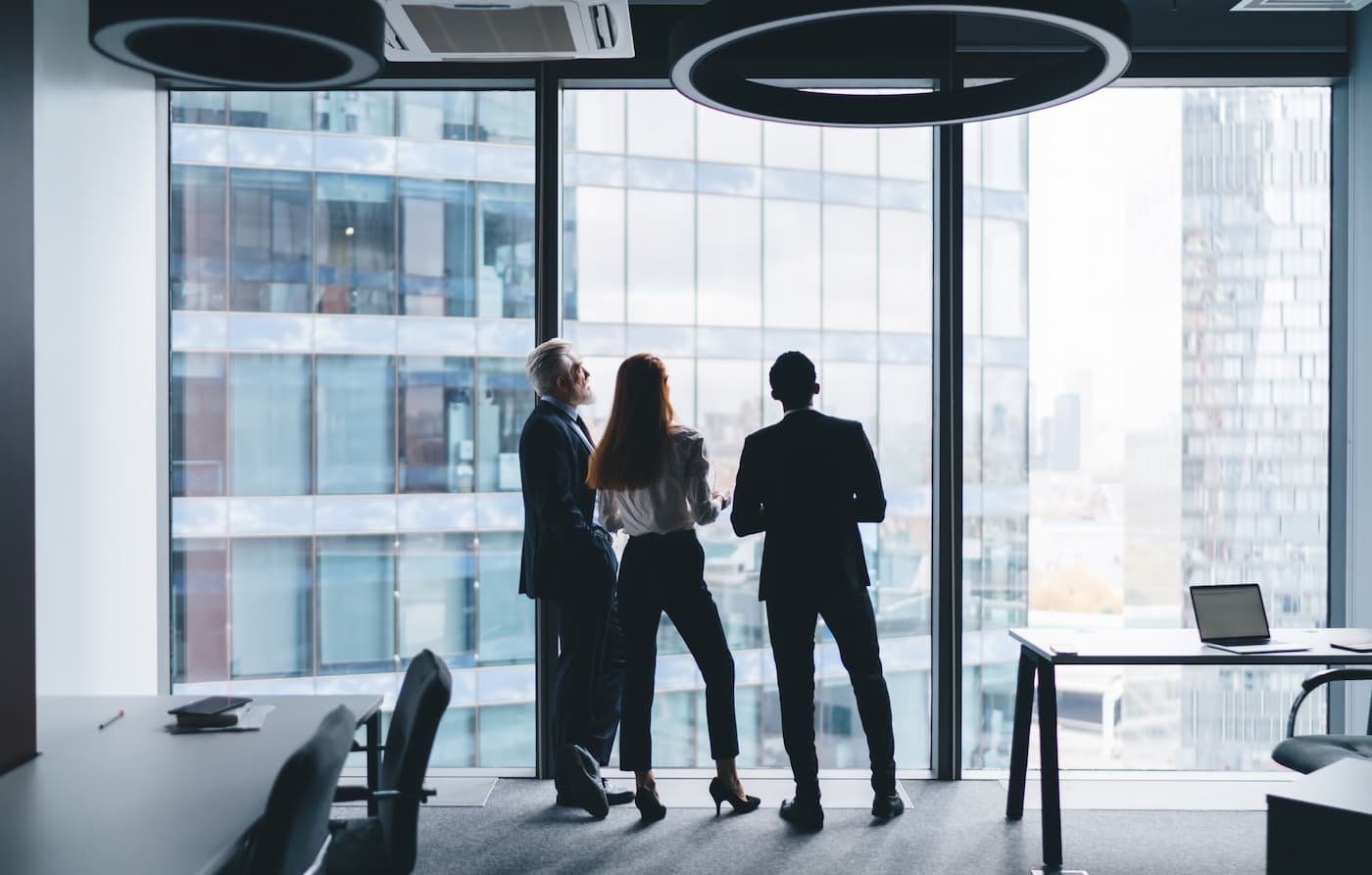 Fachada corporativa con siluetas de profesionales, representando la expansión empresarial en México